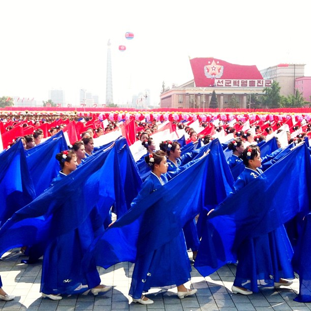 Изпълнители пресъздават флага на Северна Корея на улицата.