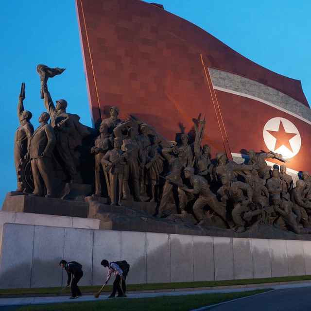 Доброволци, изпълняващи ролята на улични метачи в областта на иконичните бронзови статуи на Ким Ир Сен и Ким Чен Ир. 