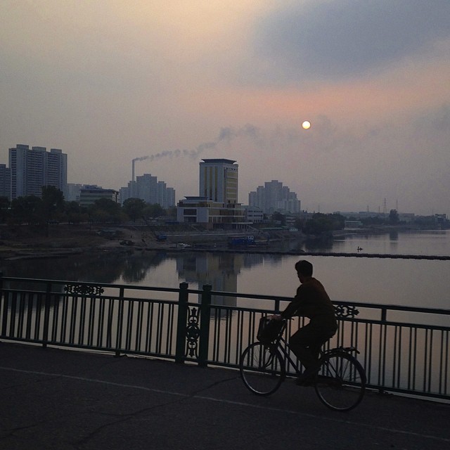 Севернокореец кара колело по залез около река Taedong, Пхенян.